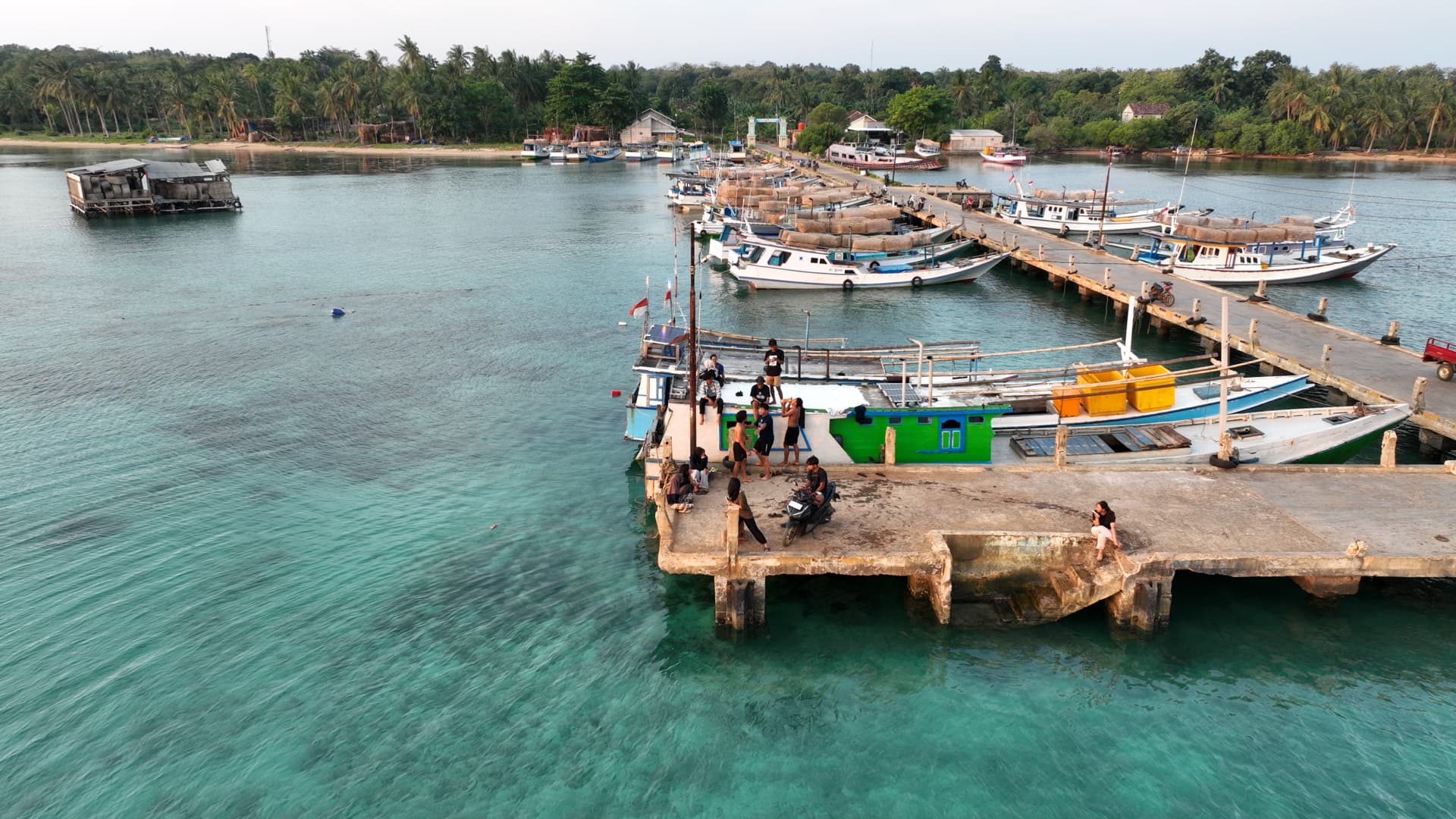 Dermaga Pulau Parang menjelang sore — perahu nelayan bersandar dan warga berkumpul.