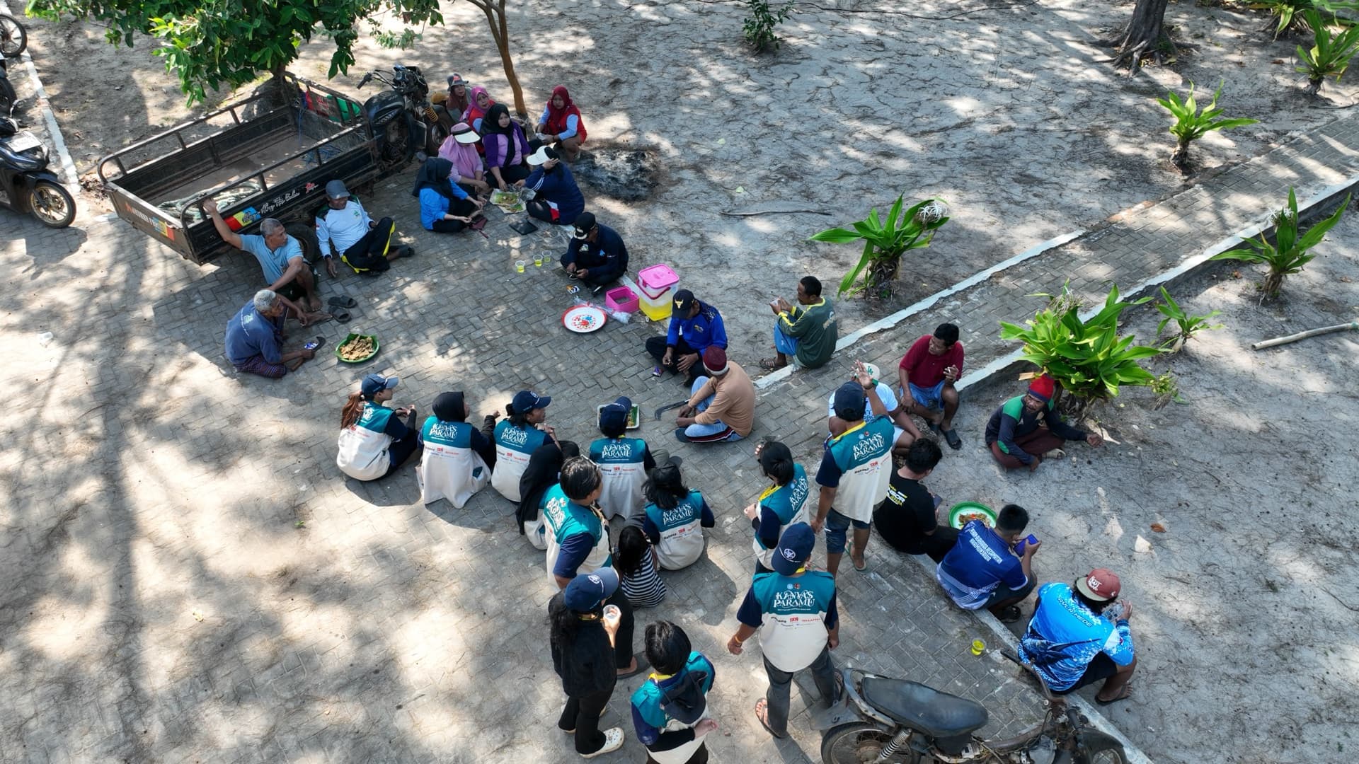 Warga bersama tim KKN-PPM UGM Kanvas Paramu berkumpul di tepi pantai.